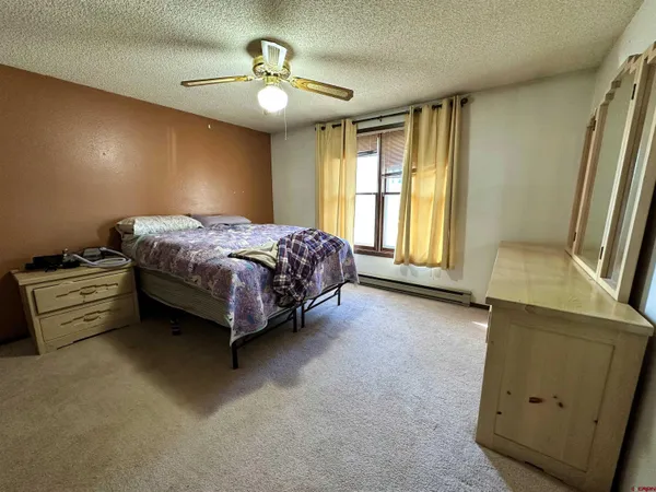 a spacious bedroom with a bed and a dresser