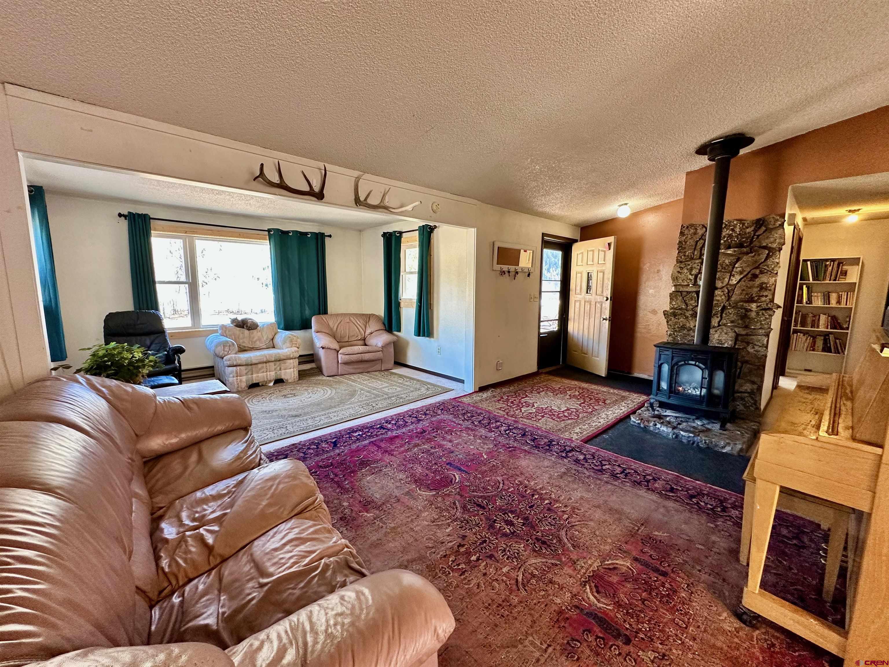 9437 County Road 76 Ohio City, CO 81239 - Photo 8 of 29 a living room with furniture hard wood floor and a fireplace