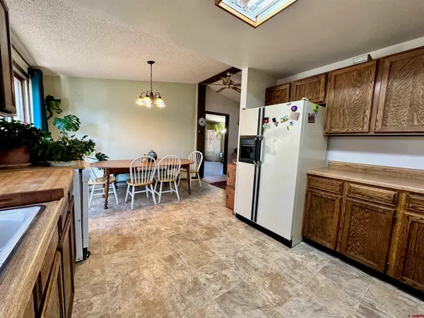 a kitchen with stainless steel appliances granite countertop a refrigerator a stove and a dining table with wooden floor