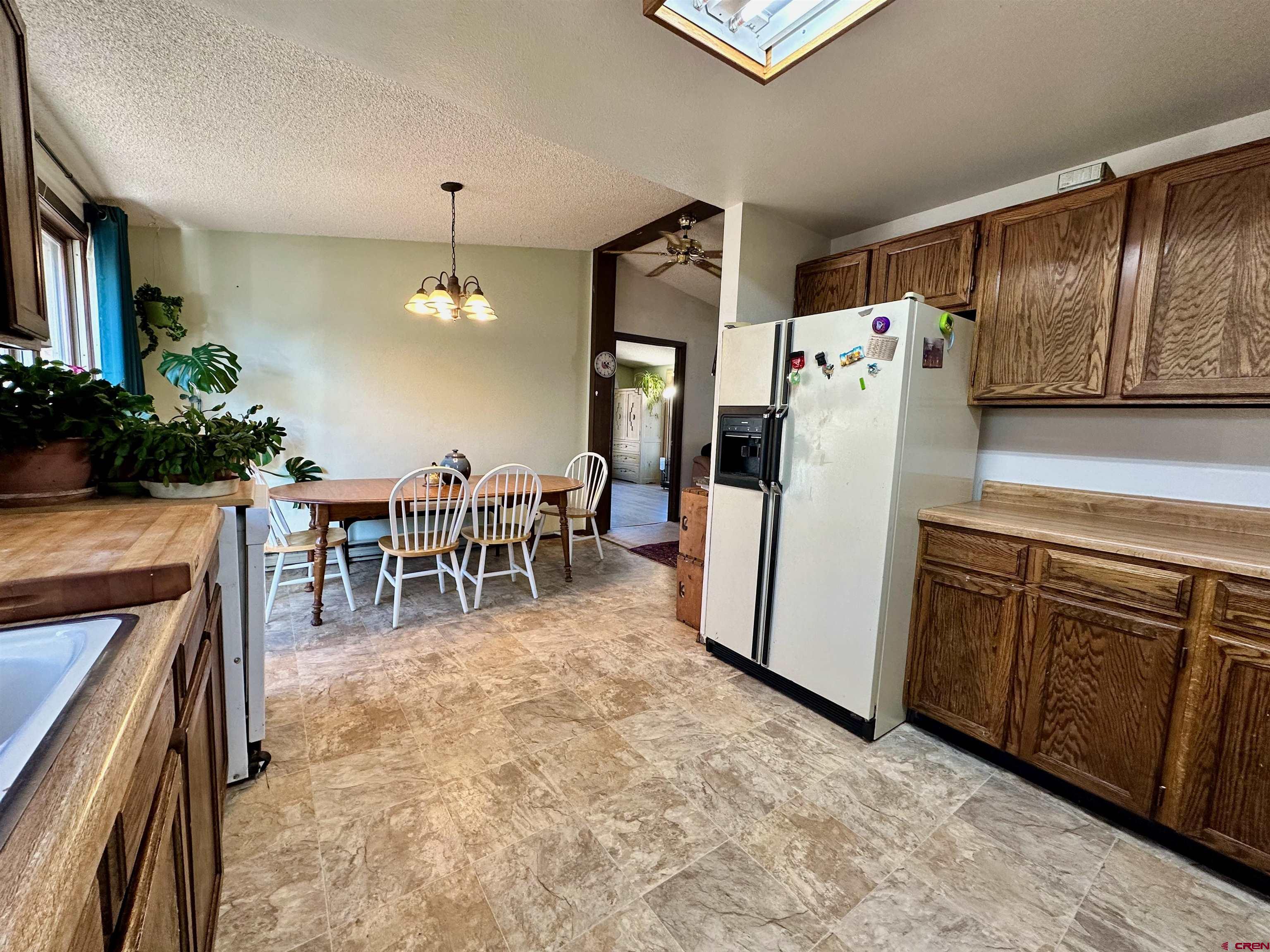 9437 County Road 76 Ohio City, CO 81239 - Photo 10 of 29 a kitchen with stainless steel appliances granite countertop a refrigerator a stove and a dining table with wooden floor