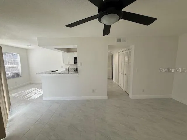a view of a kitchen with an empty space and a ceiling fan