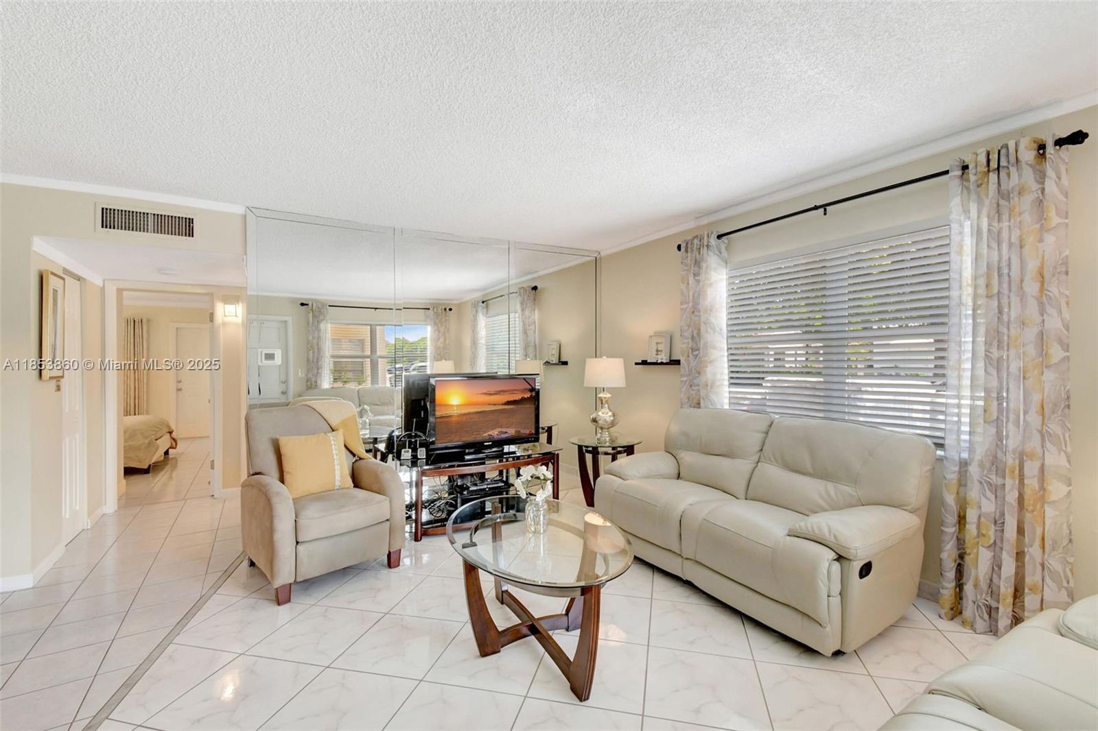 415 Northeast 2nd Street, Unit 124 Hallandale Beach, FL 33009 - Photo 12 of 36 a living room with furniture and a flat screen tv