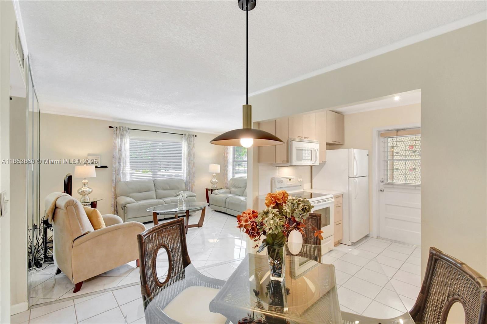 415 Northeast 2nd Street, Unit 124 Hallandale Beach, FL 33009 - Photo 16 of 36 a very nice looking dining room with a glass top table and chairs
