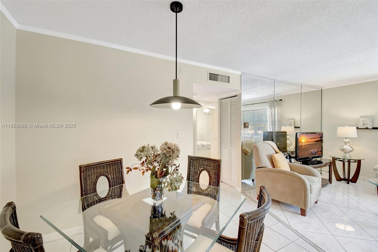 415 Northeast 2nd Street, Unit 124 Hallandale Beach, FL 33009 - Photo 17 of 36 a dining room with furniture a chandelier and window