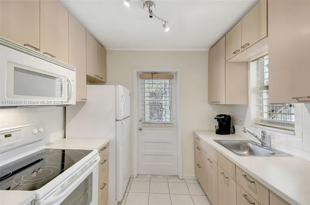 a kitchen with white cabinets and white appliances