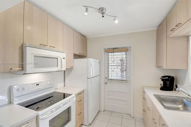 a kitchen with a sink a table and chairs in it