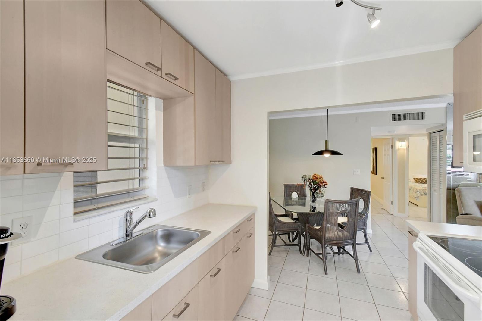 415 Northeast 2nd Street, Unit 124 Hallandale Beach, FL 33009 - Photo 20 of 36 a kitchen with a sink a table and chairs in it