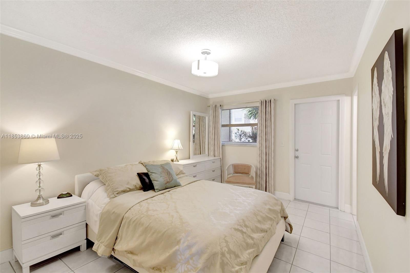 415 Northeast 2nd Street, Unit 124 Hallandale Beach, FL 33009 - Photo 22 of 36 a spacious bedroom with a bed and a lamp