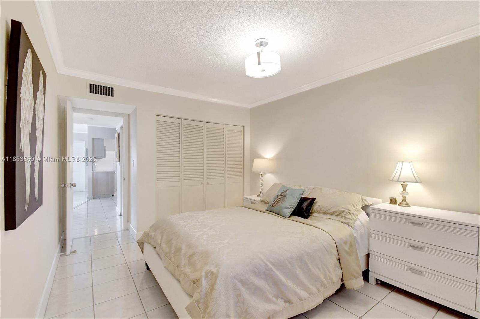 415 Northeast 2nd Street, Unit 124 Hallandale Beach, FL 33009 - Photo 24 of 36 a bedroom with a bed and a lamp