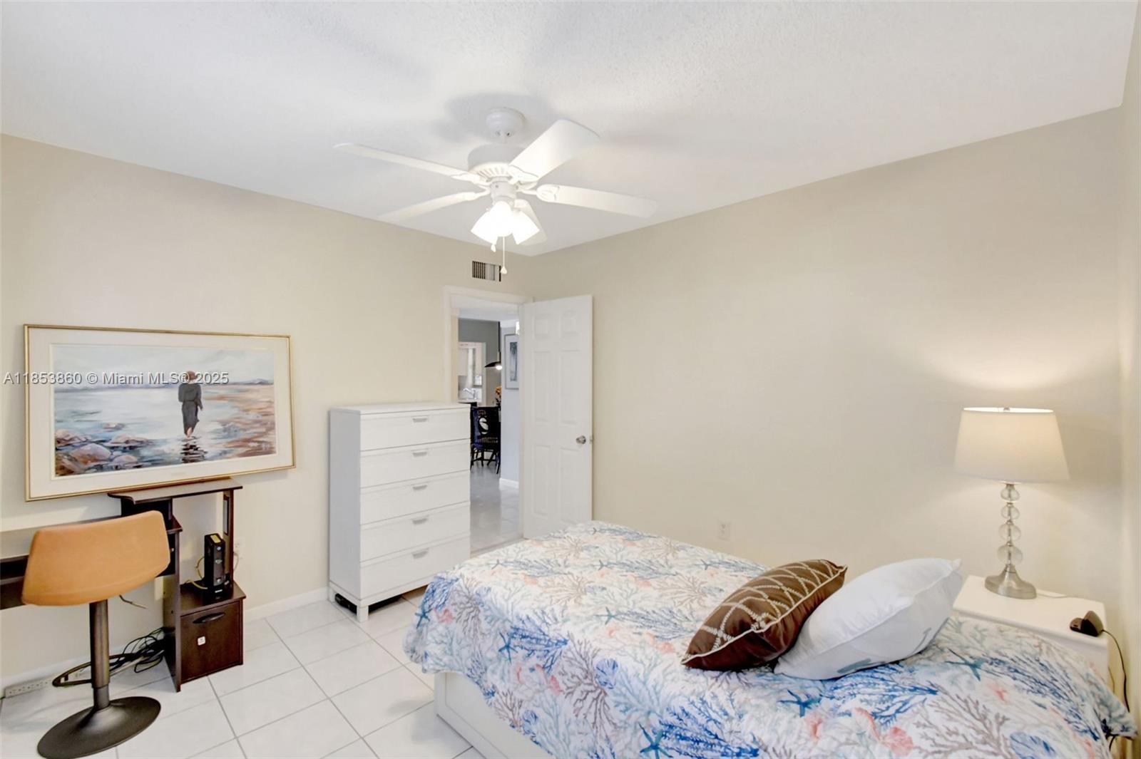 415 Northeast 2nd Street, Unit 124 Hallandale Beach, FL 33009 - Photo 30 of 36 a bedroom with a bed and a chandelier