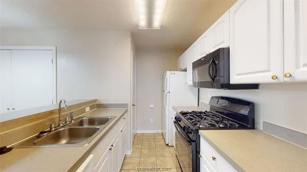 a kitchen that has a sink and a stove top oven