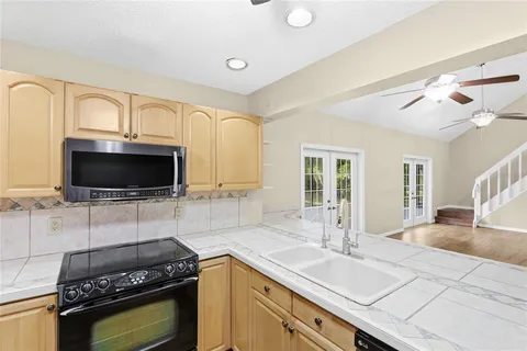 a kitchen with granite countertop a sink a stove and cabinets