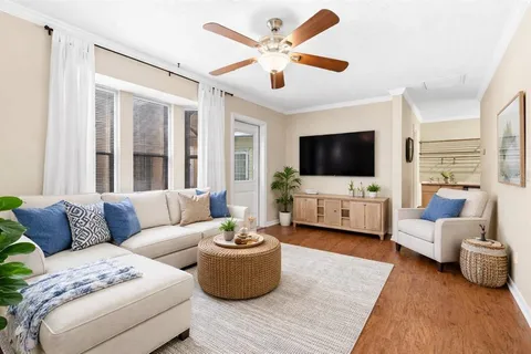 a view of empty room with wooden floor and fan