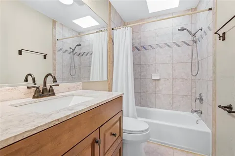 a bathroom with a granite countertop sink a mirror and a shower