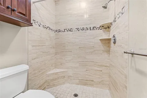 a bathroom with a shower a toilet and sink