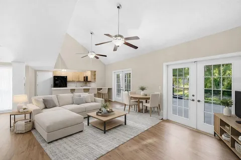 a living room with furniture ceiling fan and a window