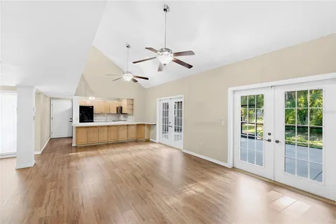 a view of a kitchen with wooden floor and a ceiling fan