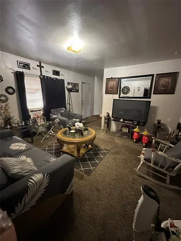 a living room with furniture a flat screen tv and gym equipment