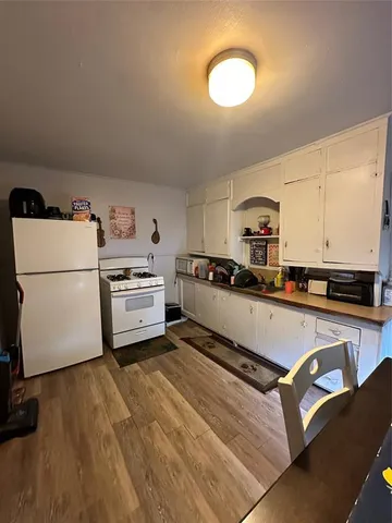 a kitchen with a refrigerator a stove top oven and a sink