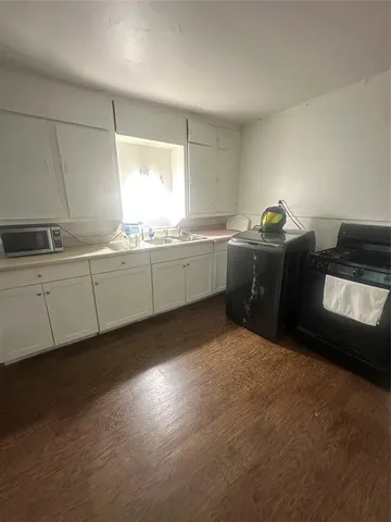 a room with granite countertop cabinets and window