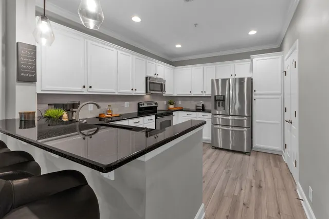 a kitchen with stainless steel appliances a refrigerator sink and cabinets