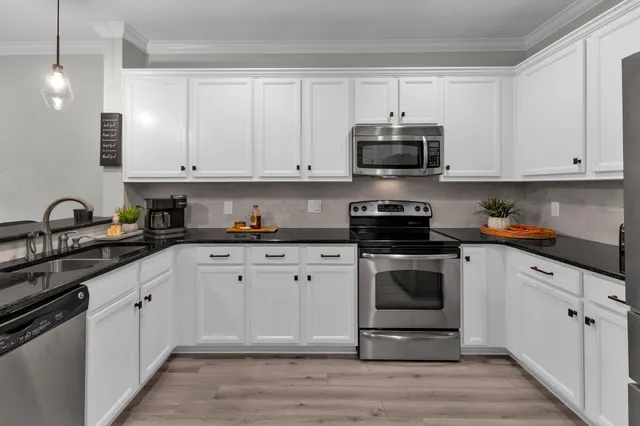 a kitchen with stainless steel appliances granite countertop a sink a stove and cabinets