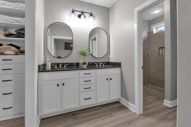 a bathroom with a granite countertop sink and a mirror