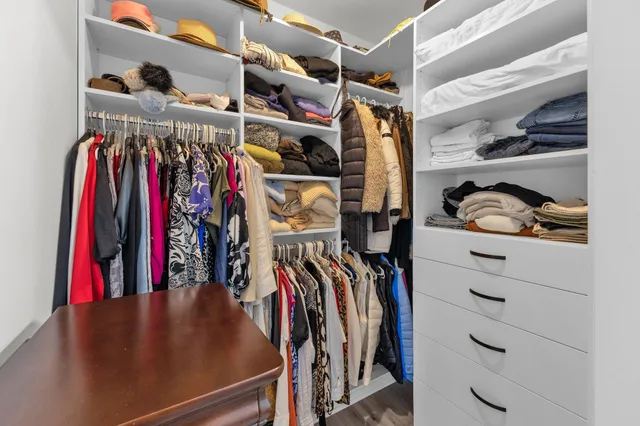 a view of walk in closet with clothes and shoes