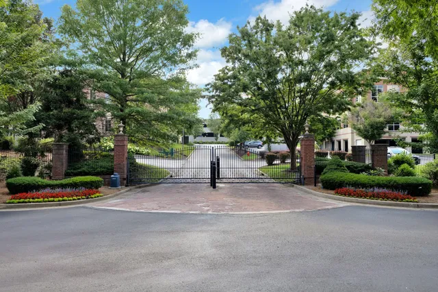 a bench is sitting in middle of a park with large trees
