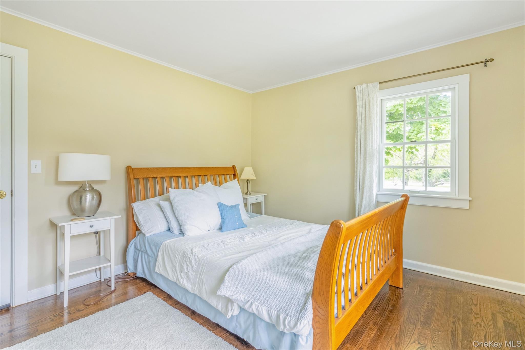 315 Wicks Road New Suffolk, NY 11956 - Photo 18 of 28 a bed sitting in a bedroom next to a window