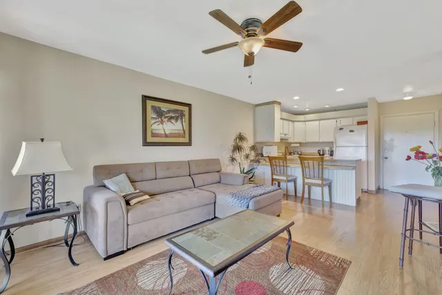 a living room with furniture kitchen view and a window