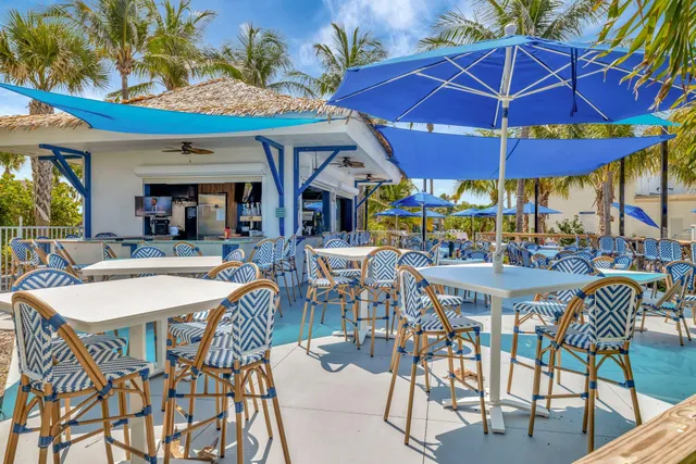 a view of a cafe with table and chairs under an umbrella