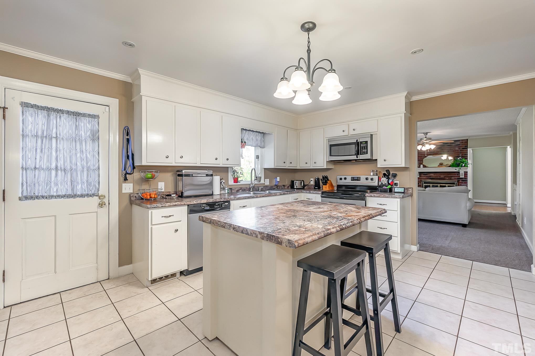 2904 Hodges Road Kinston, NC 28504 - Photo 11 of 29 a kitchen with stainless steel appliances kitchen island granite countertop a stove a sink dishwasher and a refrigerator with white cabinets