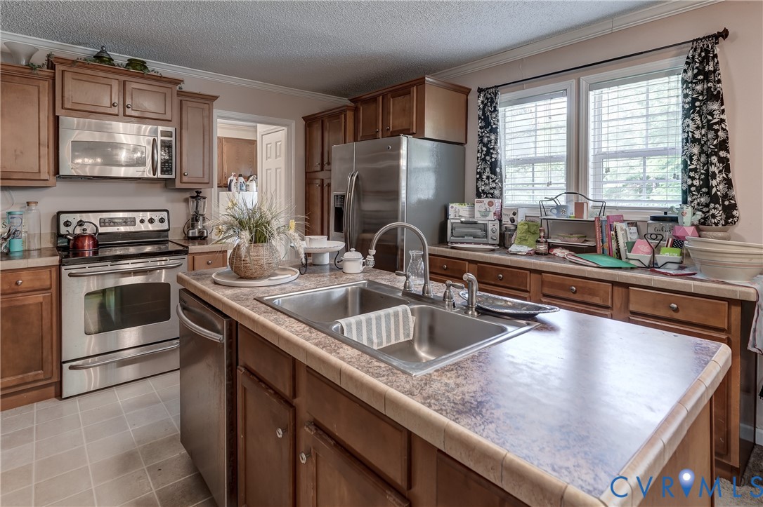 8025 Colemans Lake Road Church Road, VA 23850 - Photo 11 of 21 a kitchen with kitchen island granite countertop a sink a counter top space stainless steel appliances and cabinets