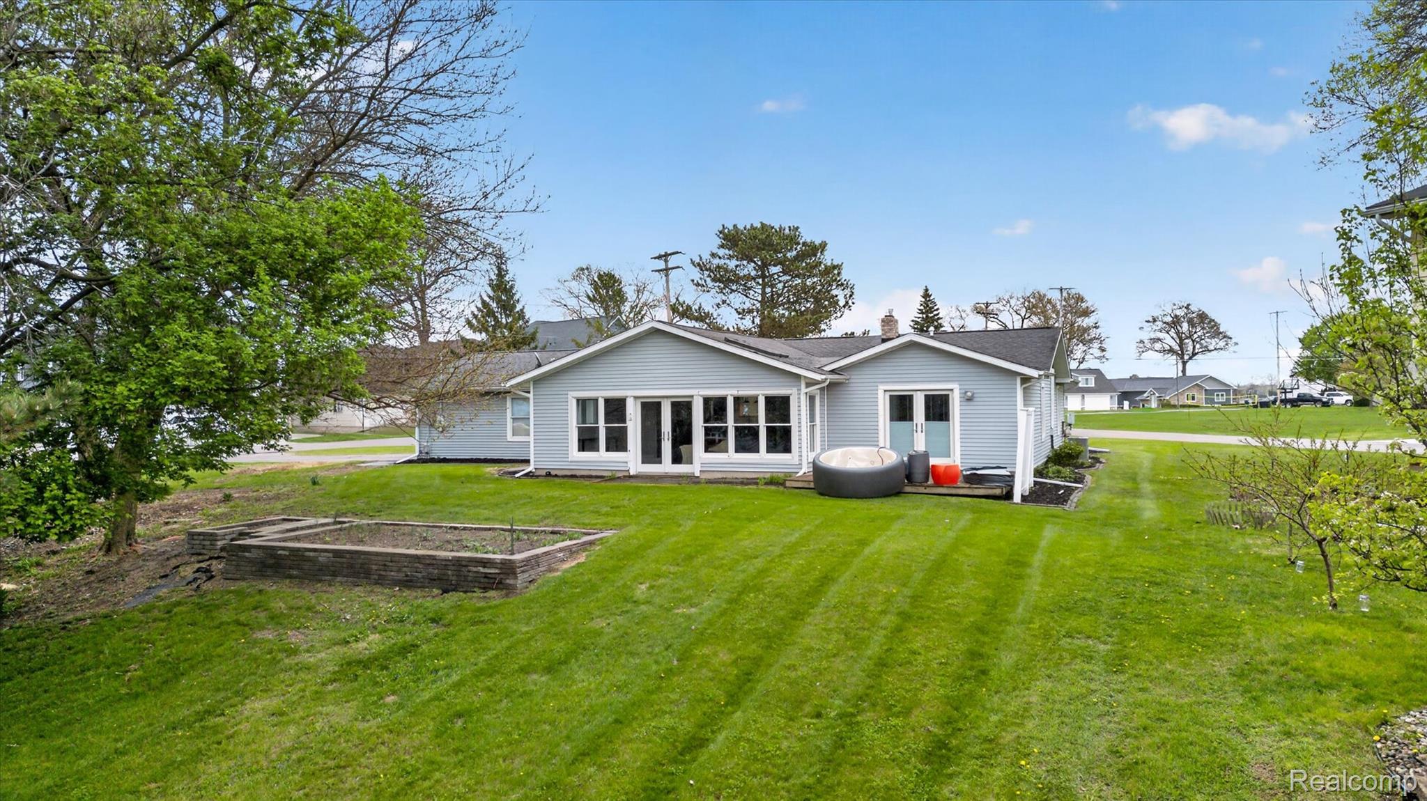 2264 Crane Road Fenton, MI 48430 - Photo 5 of 55 Rear view of property featuring a vegetable garden, a yard, and a chimney