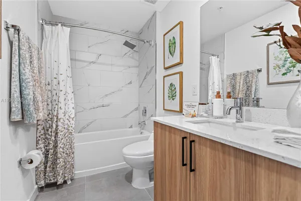 a bathroom with a granite countertop sink a toilet and shower
