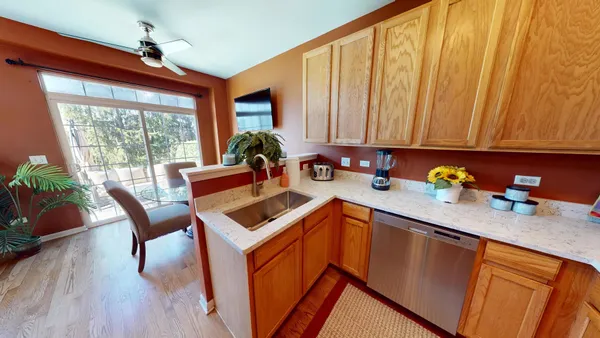 a kitchen with stainless steel appliances granite countertop sink microwave refrigerator and wooden floor