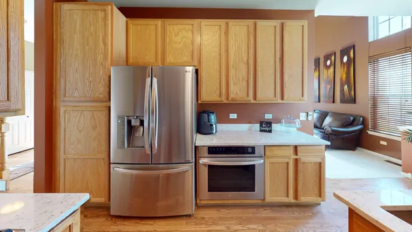 a kitchen with a refrigerator and a stove top oven
