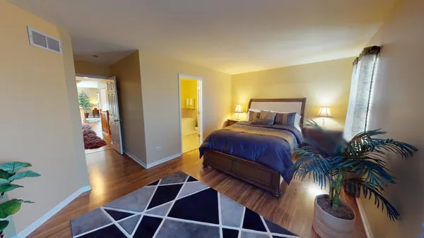a bedroom with a bed and a potted plant
