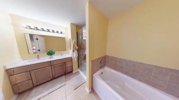 a bathroom with a tub a sink and mirror