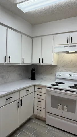 a kitchen with white cabinets and white appliances