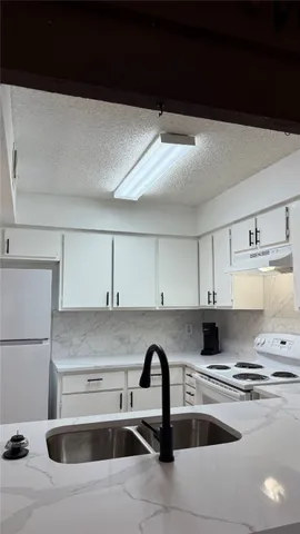 a kitchen with stainless steel appliances a sink a stove and a refrigerator