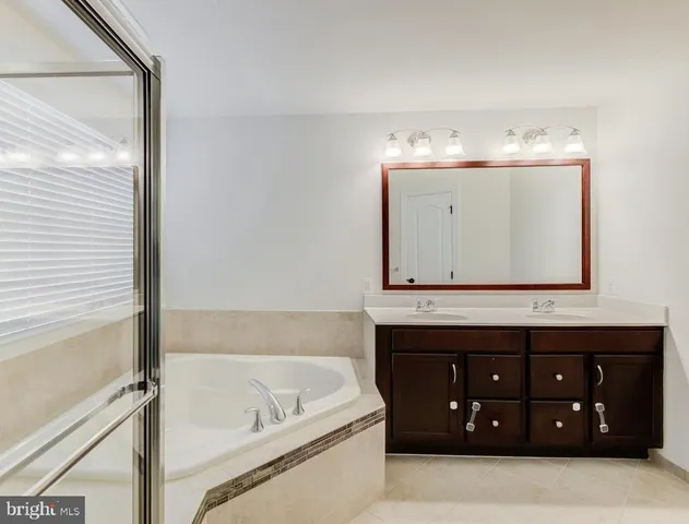 a bathroom with a tub sink and mirror