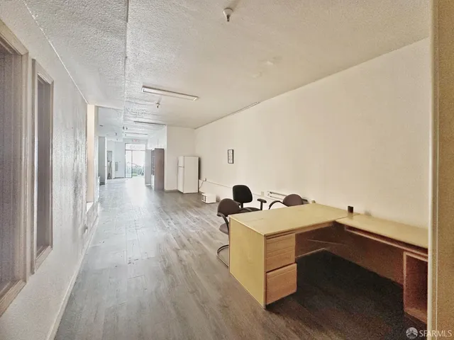 a view of a bedroom with a bed and wooden floor