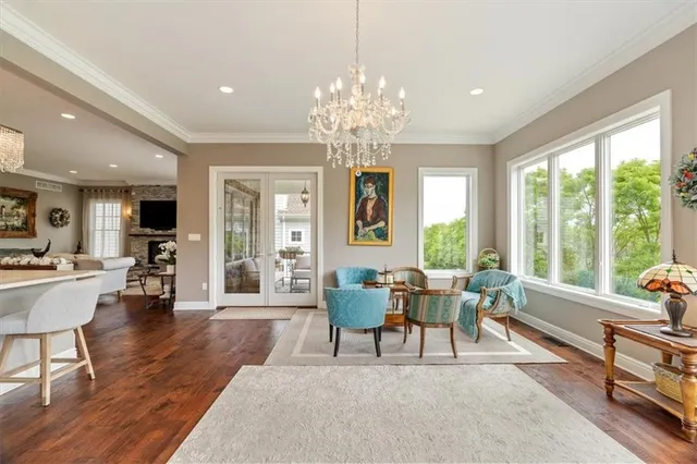 a living room with furniture a large window and dining table