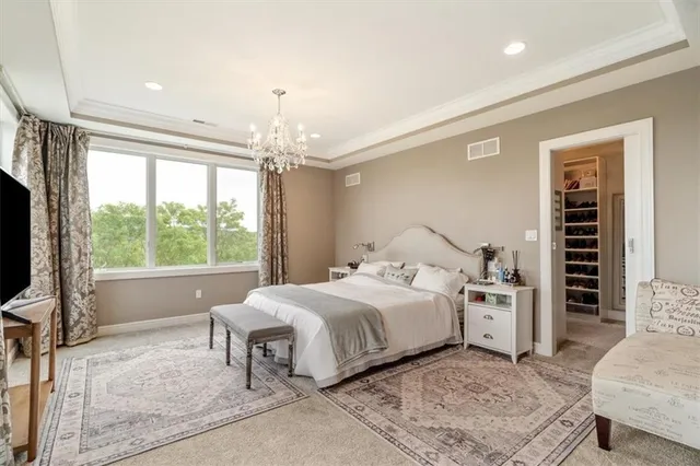a bedroom with a large bed and a chandelier