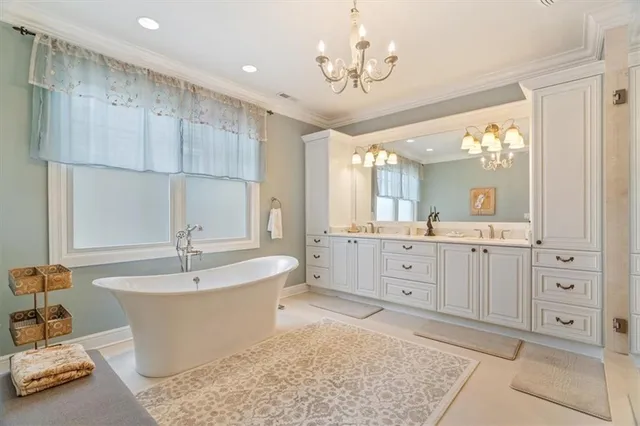 a spacious bathroom with a double vanity sink a mirror a bathtub and window