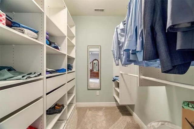 a view of walk in closet with clothes and shoes