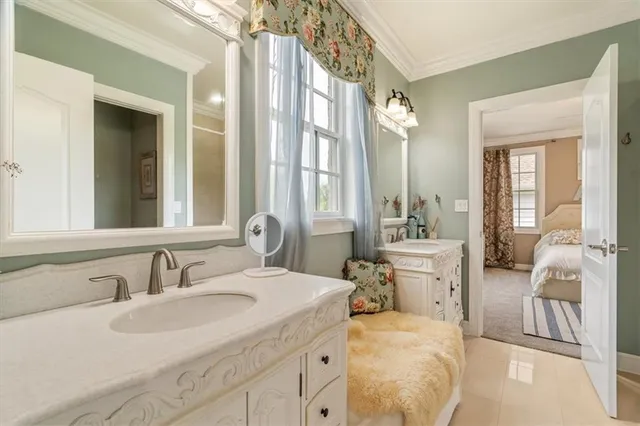 a en suite bathroom with a double vanity sink and a mirror