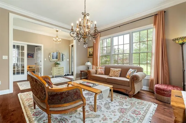 a living room with furniture a chandelier and a window